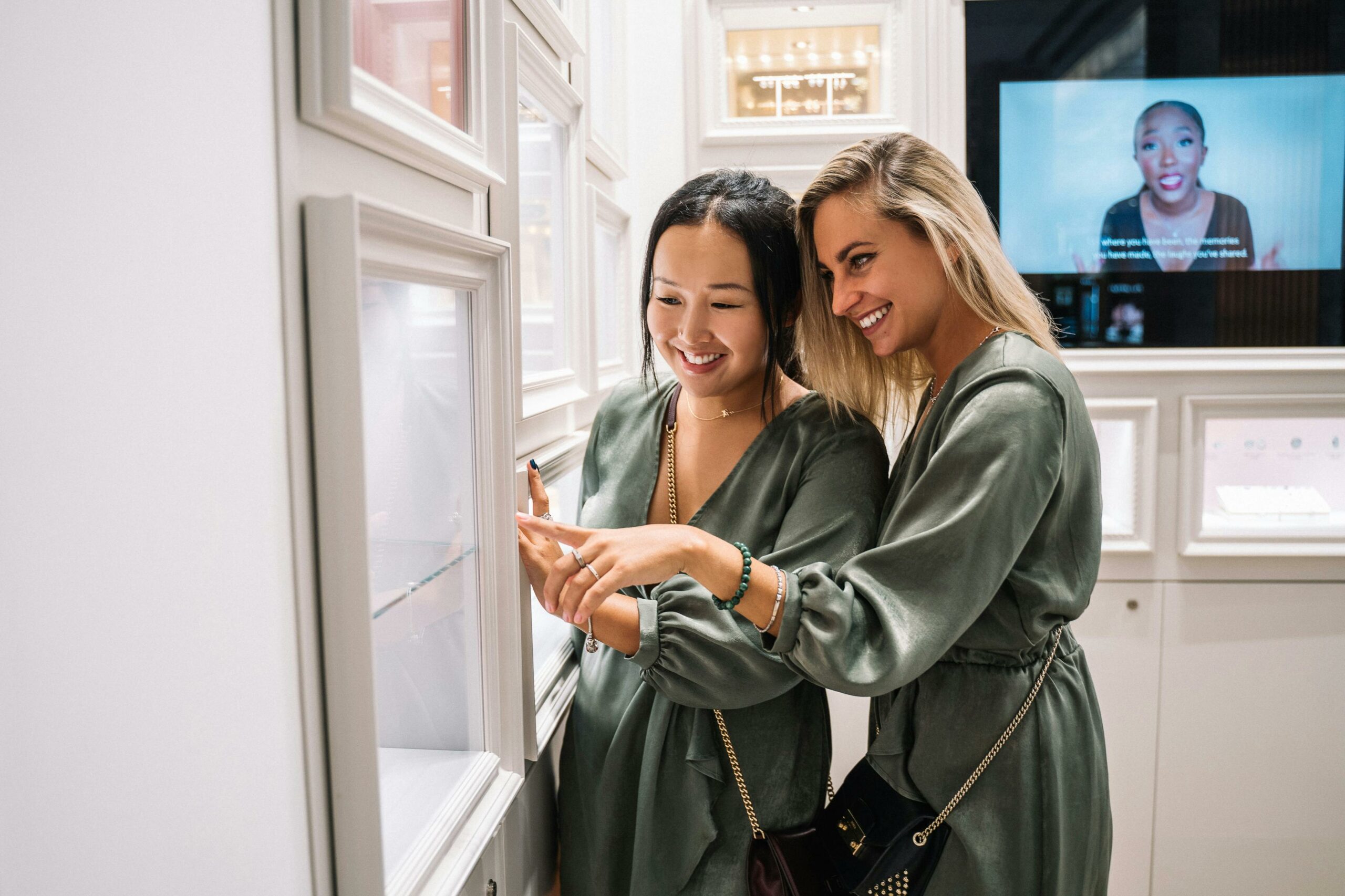 Two women joyfully shopping together in a modern jewelry store.