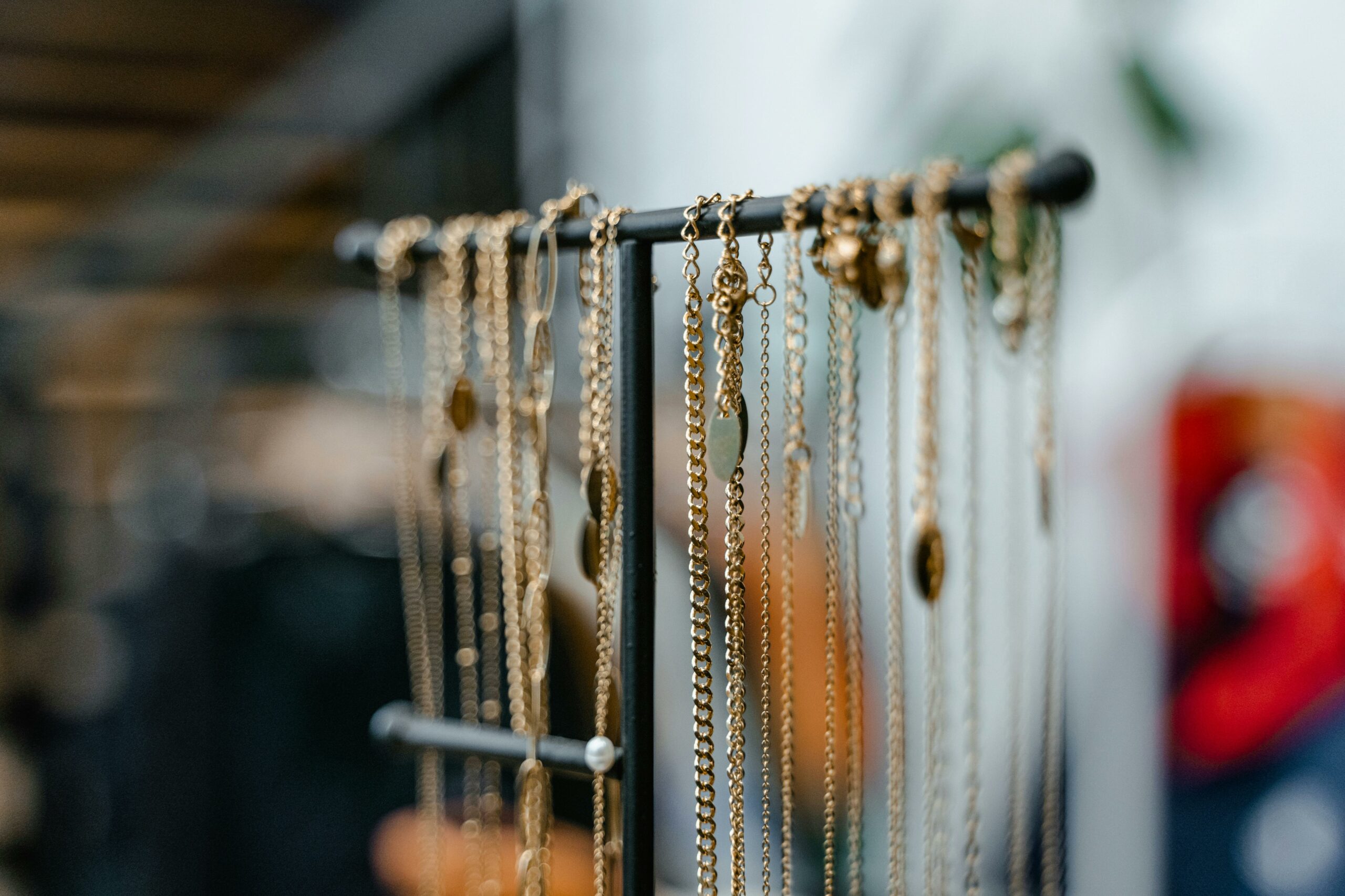 Close-up of gold necklaces displayed on a jewelry stand for elegant interior decor.