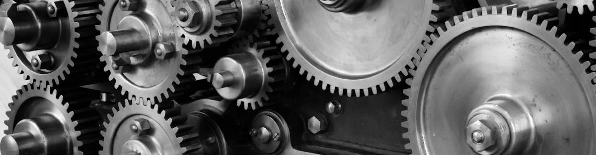 gears-cogs-machine-machinery-159298-159298 Close-up view of a complex industrial gear mechanism in black and white.