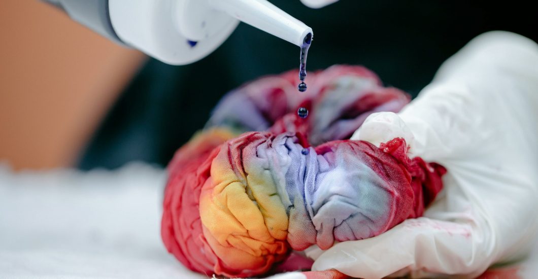 Close-up of a colorful tie-dye process using gloves and dye, showcasing a creative handmade fabric technique.